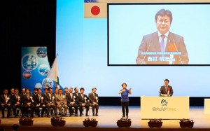 記念式典で挨拶する西村副大臣  （市民会館崇城大学ホール） 